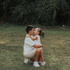 bacio tra fratelli durante un servizio fotografico nel bosco