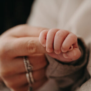 manina neonato che tiene il dito della mamma